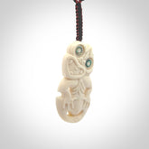Hand carved bone Tiki pendant. Traditional art hand carved for NZ Pacific. Whalebone Tiki necklace with Paua Shell eyes. Free worldwide delivery. Provided to you on a hand plaited adjustable cord.